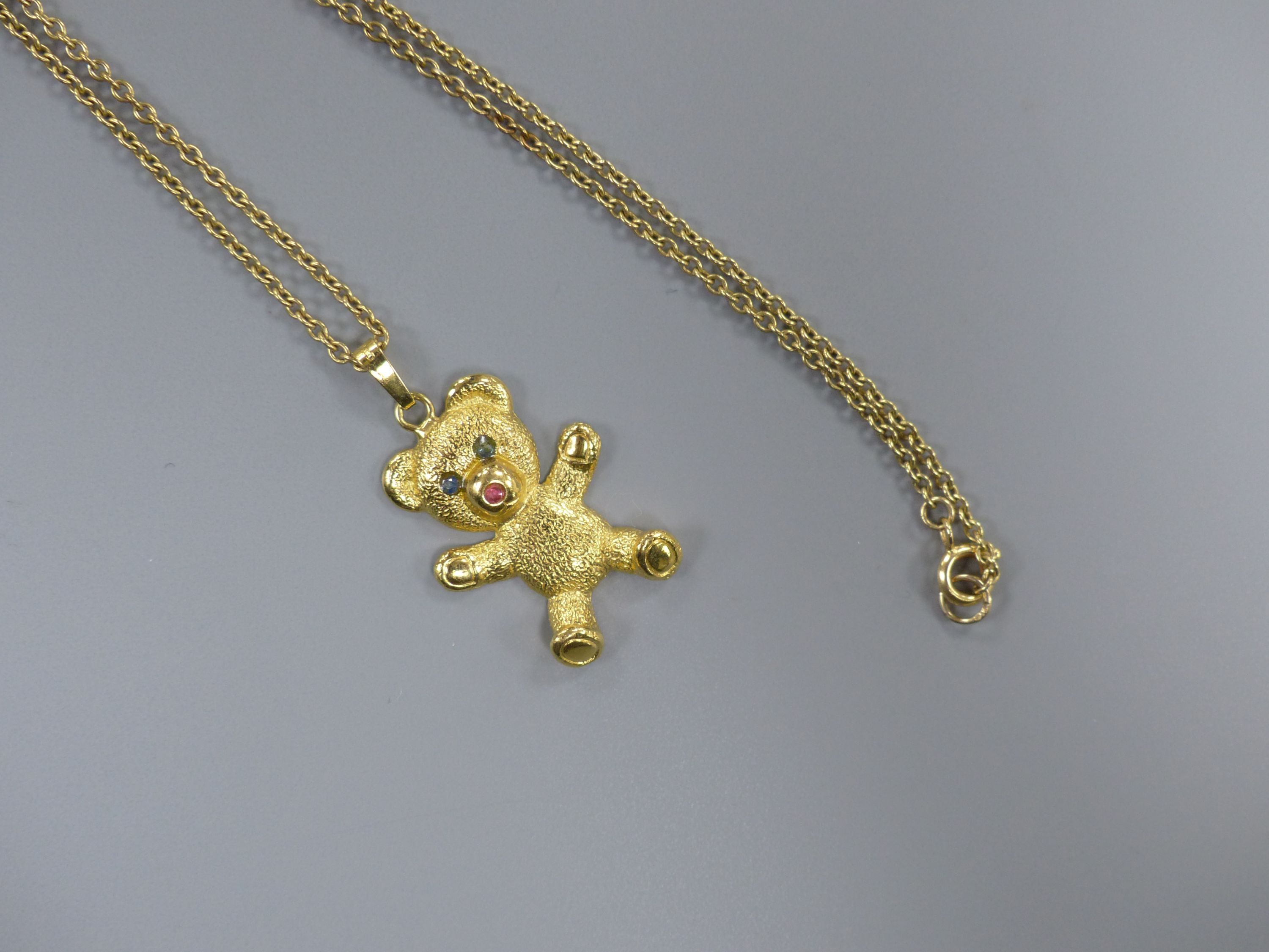 A modern 9ct gold and gem set teddy bear pendant, 26mm, on a 9ct chain, 41cm,